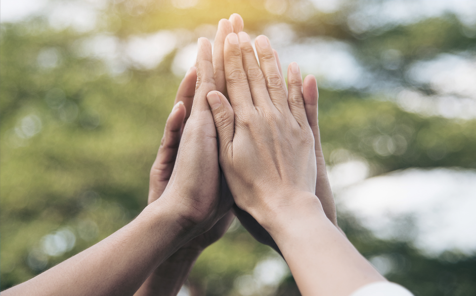 Multiple hands high fiving after paying it forward to future Canadian nurses with annual scholarship programs